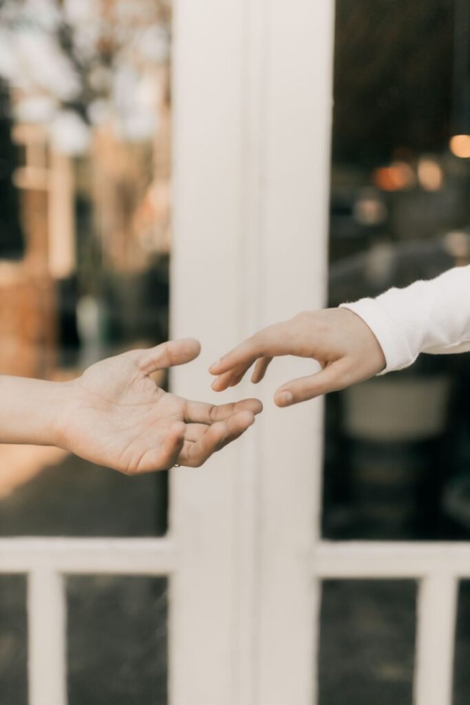 hands reaching towards each other in soft light