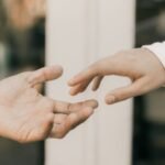 hands reaching towards each other in soft light